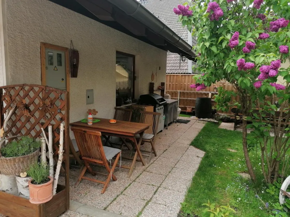 Patio in front of the house with a table and flowers